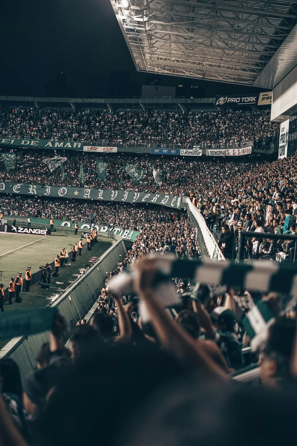 Supporters fill a stadium at night