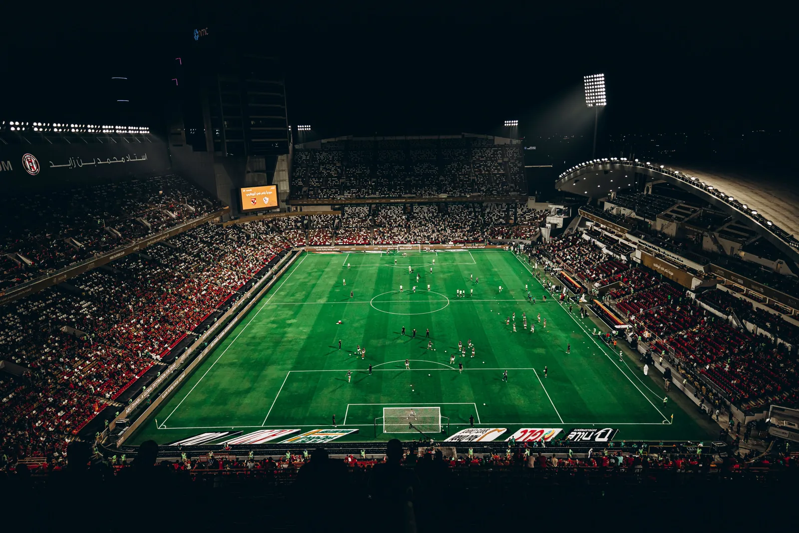 A floodlit football stadium during a night match